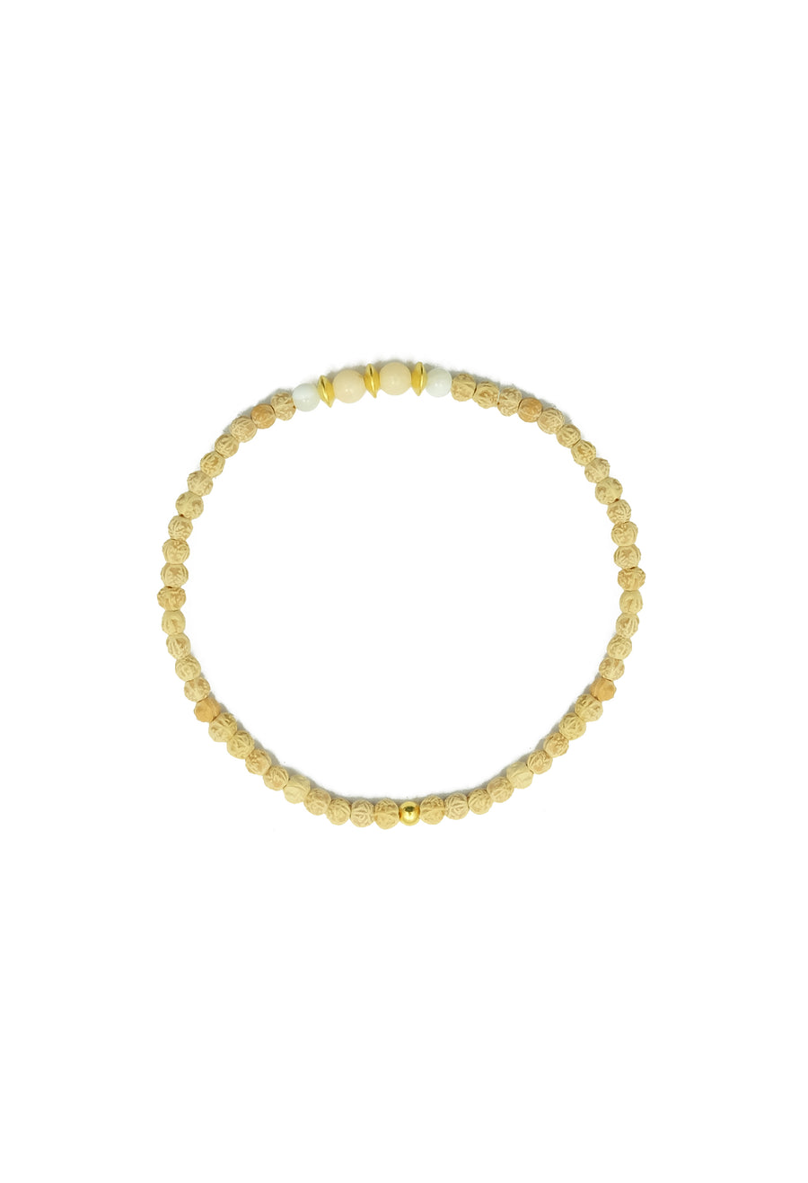A mesmerizing Uluwatu Moon Bracelet, featuring 2mm rudrani seeds, pink coral, and moonstone beads, adorned with a stunning pearl pendant and 22k gold accents. Inspired by the full-moon casting a radiant runway onto the waves of Uluwatu Beach, this celestial accessory evokes beachside meditations and invites you to trust in the magnificence of the cosmos.