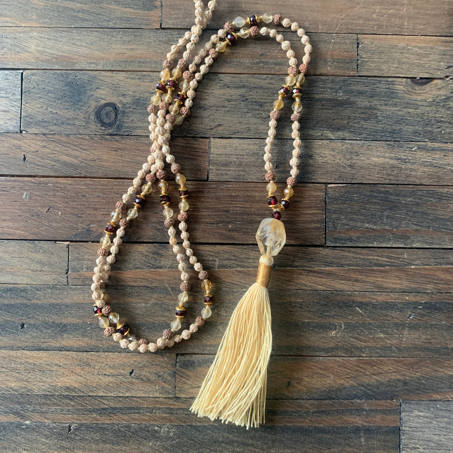 Prayer bead mala made from rudrani, rudraksha, citrine and garnet beads with cotton tassel. 