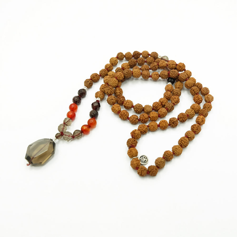 An exquisite mala with 108 beads, 7mm Rudraksha seeds, Carnelian, Garnet, Smokey Quartz gemstones, sterling silver accents, and a captivating Smokey Quartz pendant. This mala exudes a harmonious blend of beauty, grounding energy, and elegance.